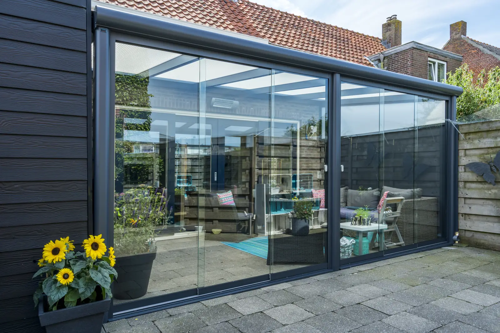 Glass veranda enclosed with sliding glass panels and an infrared heater mounted in the frame
