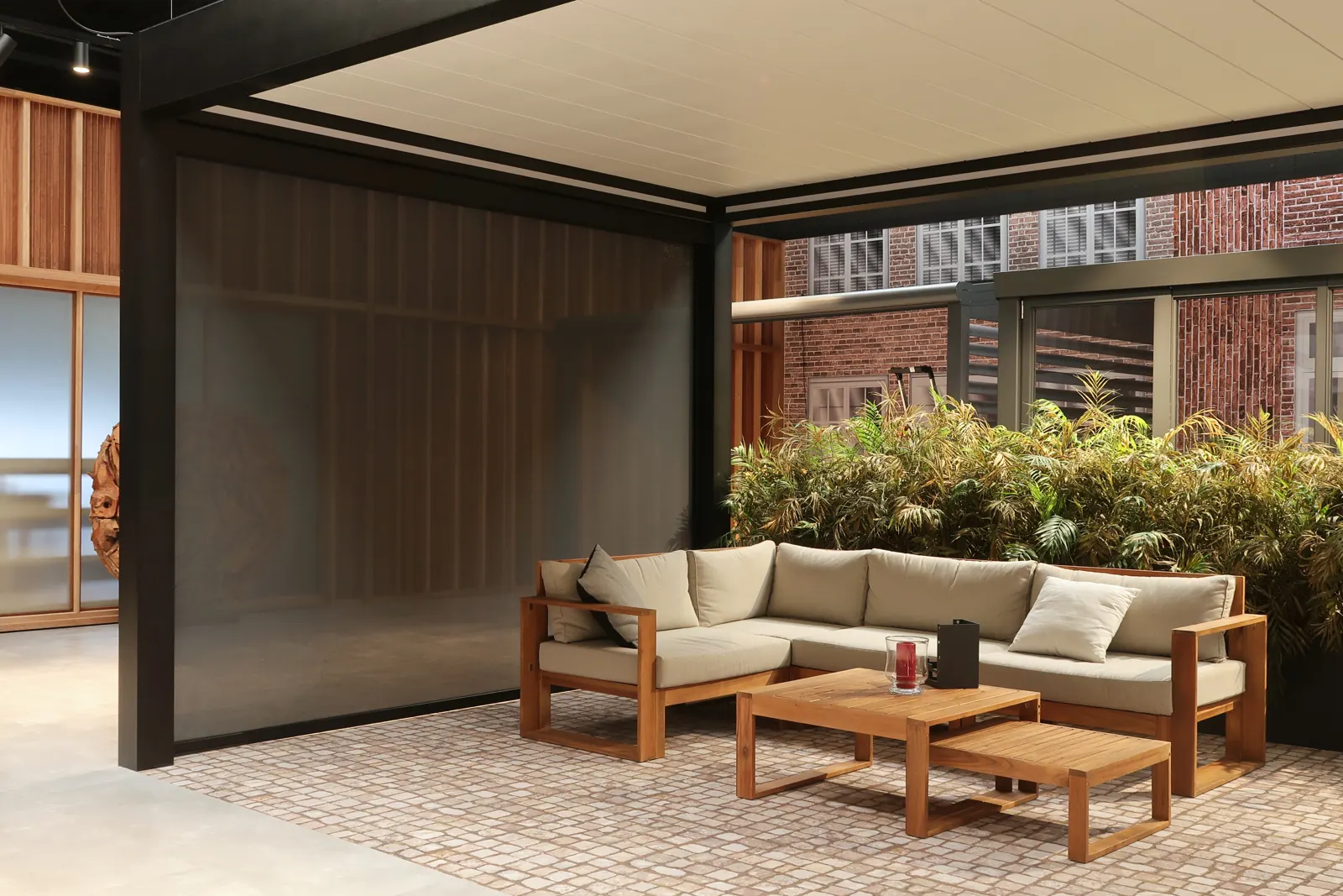 Zip screen lowered on the side of a pergola beside an outdoor sofa