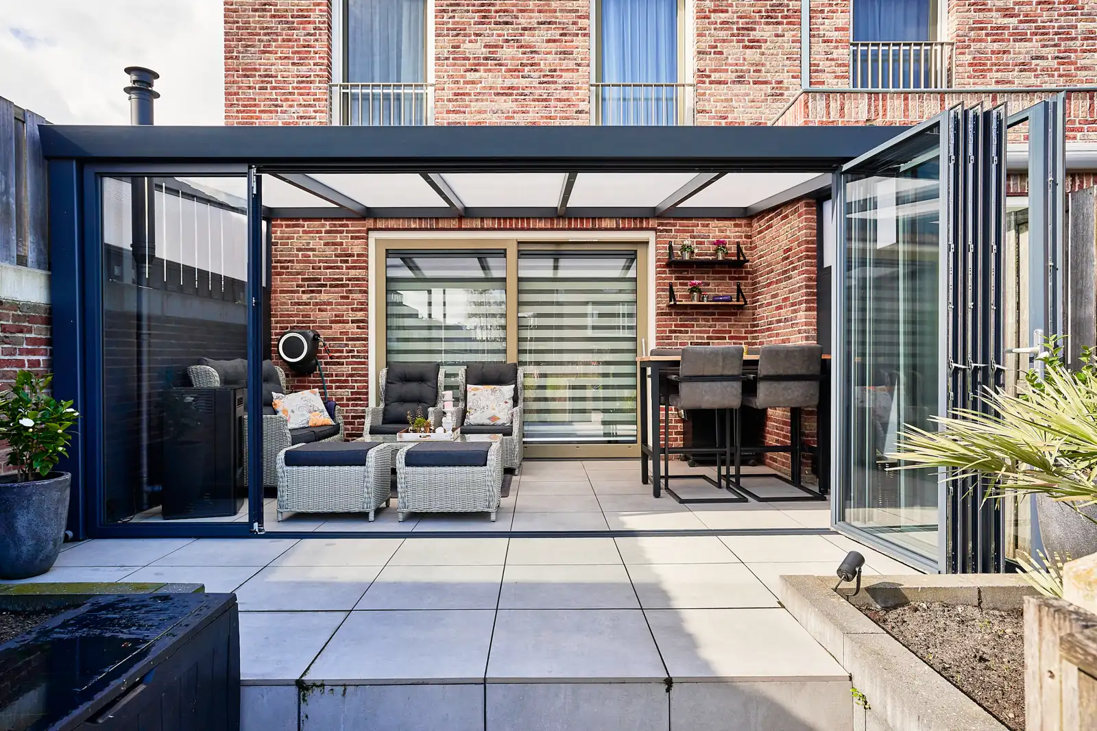 Lean-to veranda with glass sliding doors attached to a brick house