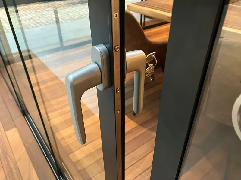 Close view of the locking handle and key on a Deponti Fiano glass sliding wall