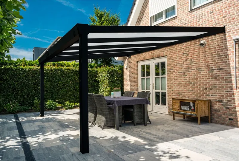 Deponti Giallo veranda in anthracite over a patio dining set beside a brick house