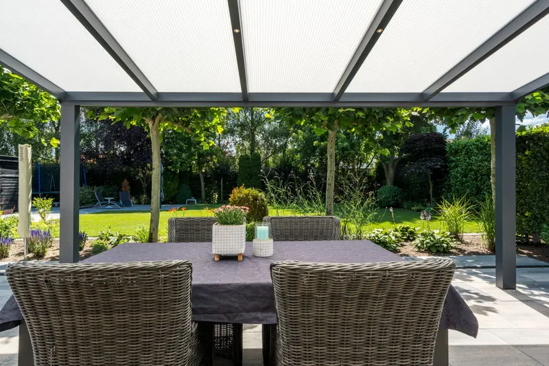 View from under a Deponti Giallo veranda roof across a dining table to the garden