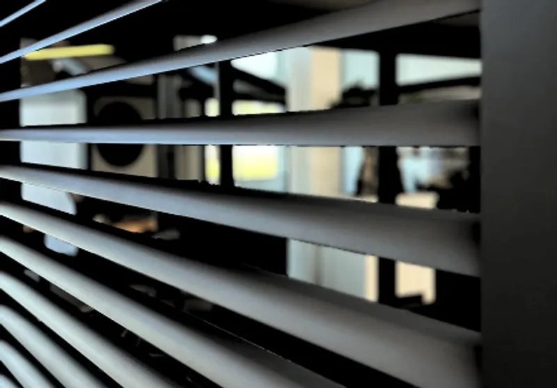 Deponti Louvres black oval slats set in a dark aluminium frame, seen at an angle