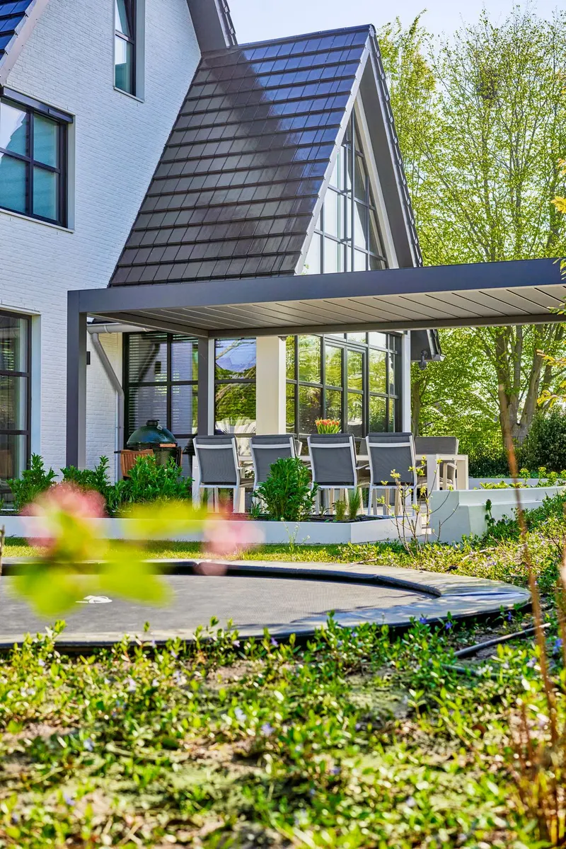 Wall-mounted Deponti Pinela Deluxe over a dining terrace at the back of a gabled house