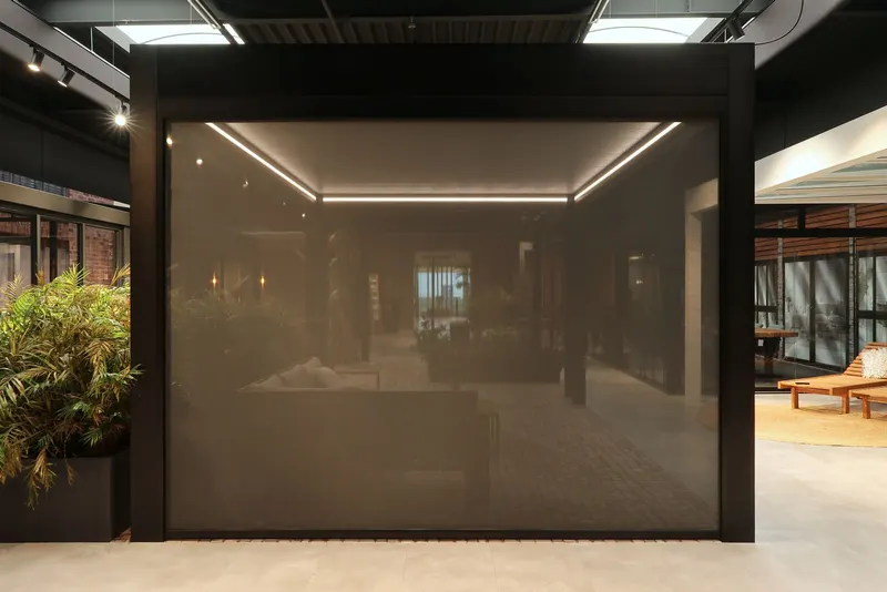 Deponti Screen fully closed between black posts with LED lighting glowing behind the mesh