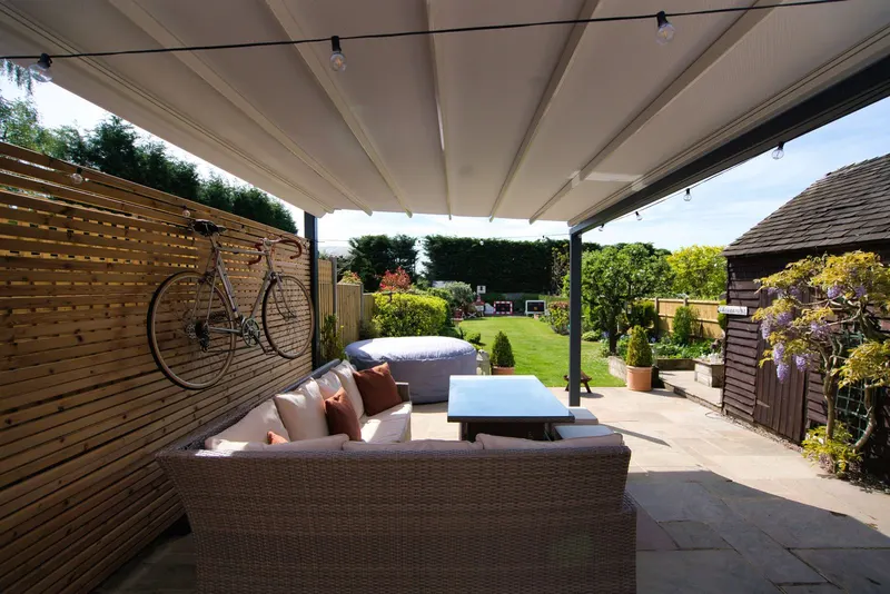 Rattan sofa and dining table under the closed fabric roof of a Deponti Verdeca