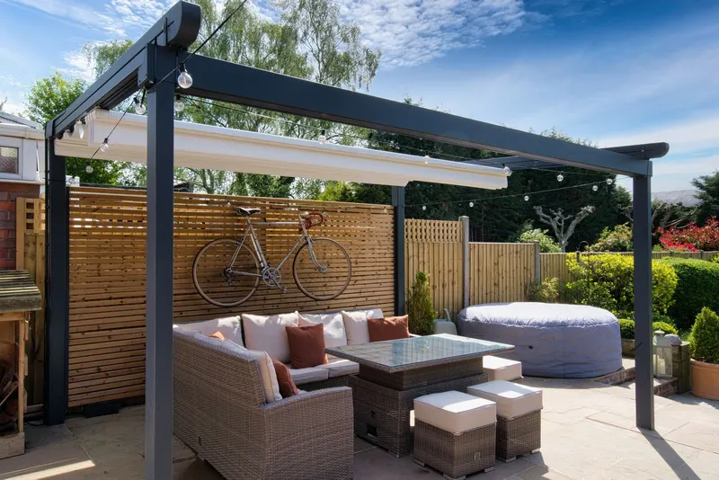 Deponti Verdeca pergola frame with the fabric roof retracted above an outdoor lounge set