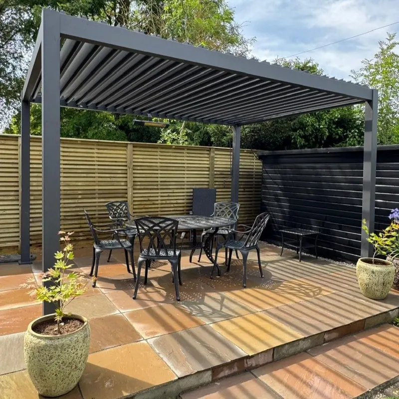Eden Titan pergola with anthracite louvred roof over a cast iron dining set on sandstone paving