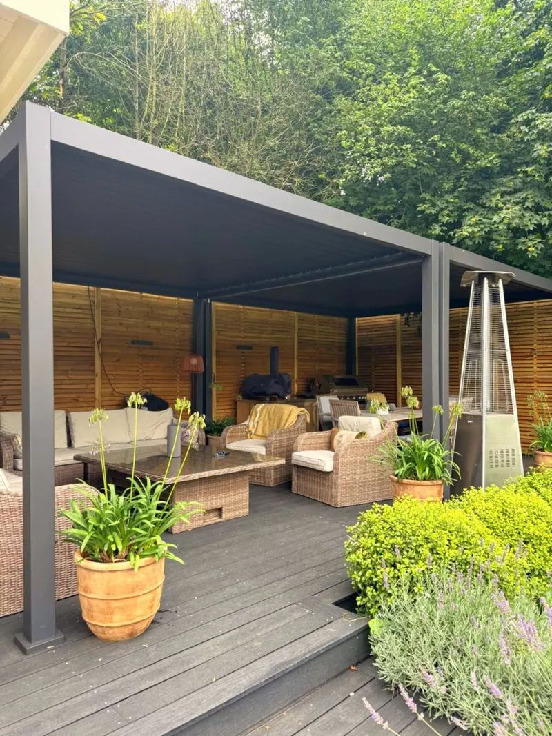 Eden Titan pergola over composite decking with wicker lounge seating, patio heater and potted agapanthus