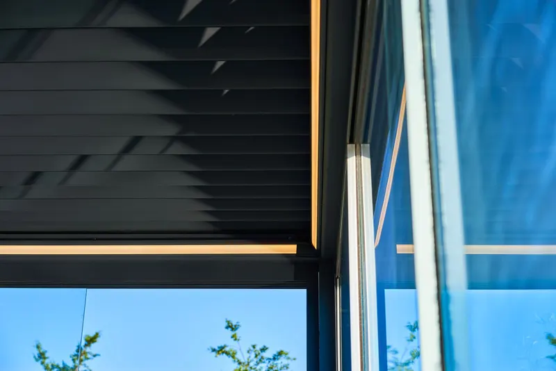 Underside of closed Pinela Deluxe aluminium panels meeting the glass sliding walls