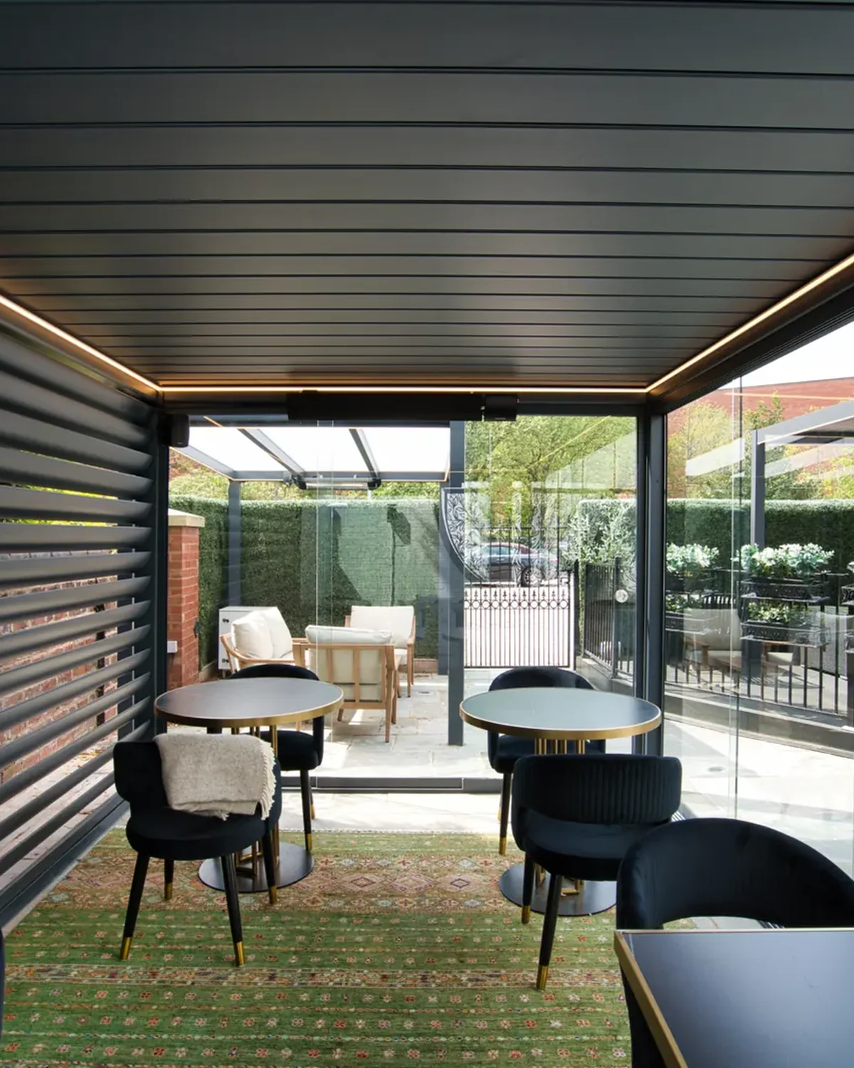 Bioclimatic pergola with louvred roof, glass sides and LED lighting